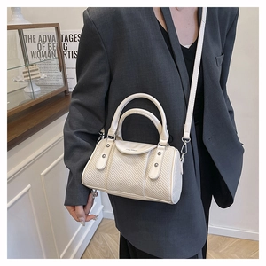 Detail der cremefarbenen gewebten Boston-Tasche mit feinem Muster und Ledergriffen