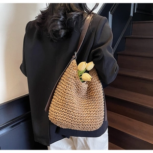 Borsa a tracolla in paglia intrecciata marrone con cinturino in pelle indossata sul retro
