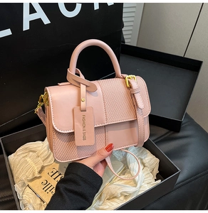 Detail view of pink PU leather and tweed crossbody bag in premium gift box packaging