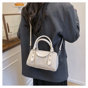 Detail of chic ivory pillow bag showing leather textures and adjustable shoulder strap