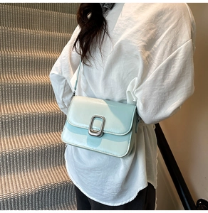 Detail shot of mint green square bag showing smooth glossy texture and silver metal buckle