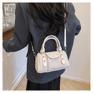 Chic cream Boston bag with woven texture shown on model to demonstrate size and style