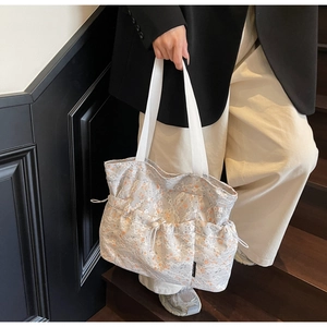 Detail of floral lace tote bag with orange flowers and adjustable side drawstring design