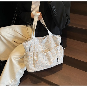 Close-up of floral lace tote bag with drawstring pocket on a soft background