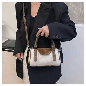 Modell mit Retro-Canvas-Boston-Tasche, Lederriemen und Nietenverzierung im Kontrastdesign