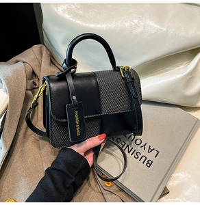 Detail of black crossbody bag featuring contrast textures and gold hardware accents