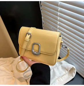 Detailed shot of yellow leather mini square bag with silver buckle and adjustable strap