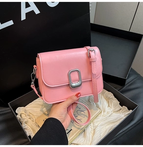 Pink minimalist square bag with silver metal buckle on elegant black gift box display