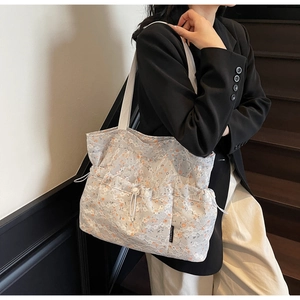 Detail of floral lace tote bag featuring adjustable drawstring side pockets and canvas strap