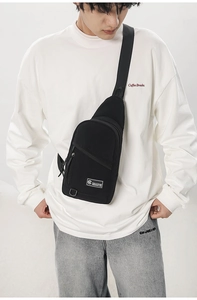 Détail du sac de poitrine noir en tissu oxford avec poche frontale zippée et logo
