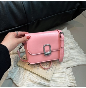 Detail of pink PU leather flap bag featuring silver rectangular metal buckle and strap