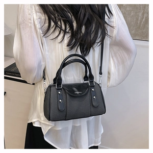 Detail of grey boston bag with black leather trim and ZHGNMA logo on shoulder