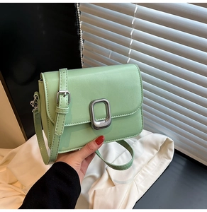 Close-up of mint green square crossbody bag with textured leather and silver lock