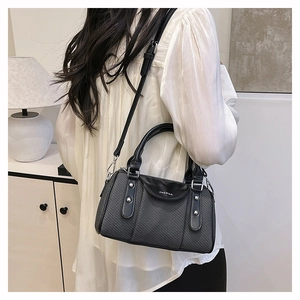 Detail of black crossbody pillow bag with ZHCNMA lettering and twill woven texture