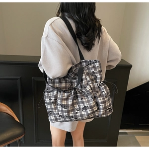 Detail of checkered canvas tote bag featuring adjustable drawstrings and butterfly patterns
