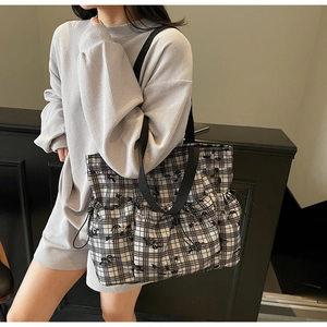 Detailed view of black and white floral canvas tote bag with drawstring side pockets