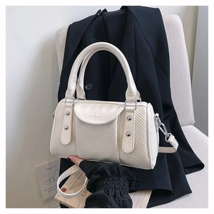 Detailed view of cream white woven boston bag with silver rivets and embossed logo