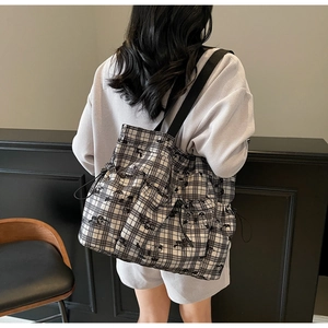 Detail of checkered canvas tote bag featuring cute cartoon dog prints and drawstring sides