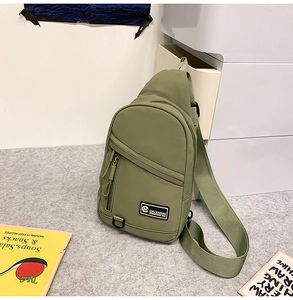 Détail du sac bandoulière en nylon vert armée avec bandoulière large et écusson