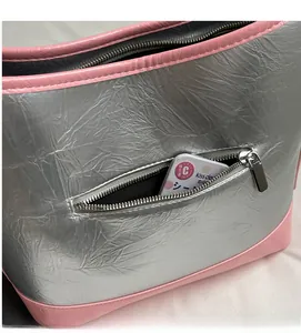 Detail of silver pleated shoulder bag showing a side zipper pocket for storage