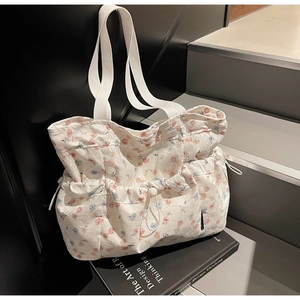 Detailed close-up of a floral canvas tote bag with drawstring and side pocket details