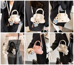 Detalle de mini bolsos bandolera con forma de concha en cuatro colores con osito
