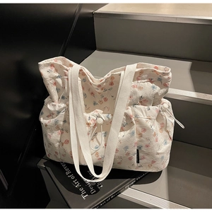 Detail of floral canvas tote bag featuring drawstring closure and soft pastel flower pattern