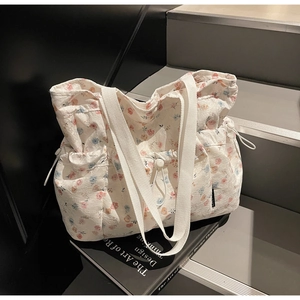 Close-up of floral tote bag featuring jacquard texture and adjustable drawstring closure
