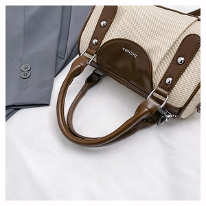 Detail shot of straw and brown leather crossbody bag with silver rivet accents