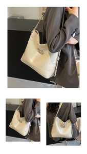 Detail of cream leather shoulder bag featuring silver bow buckle and adjustable strap