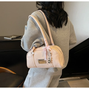 Pink patent leather bowling bag with heart pendant and ribbon details on shoulder
