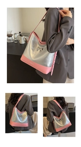 Detail of silver crinkled texture and pink leather shoulder bag with a metal bow
