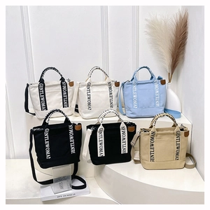 Detailed collection of canvas tote bags with GENTLEWOMAN strap on a modern white display