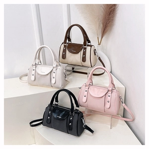 Detail showing Boston style mini handbags with woven texture, leather handles and rivets