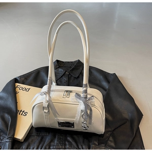 Detail of white ivory shoulder bag with checkered ribbon bow and silver metal heart charm