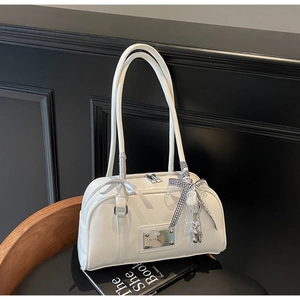 Detail of white PU leather Boston bag with lace pearl charm and checkered bow accessory