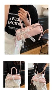 Dettaglio borsa baguette in pelle verniciata rosa con fiocco in pizzo e ciondolo di perle