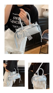 Dettaglio della borsa baguette azzurra con fiocco in pizzo e pendente in perle elegante