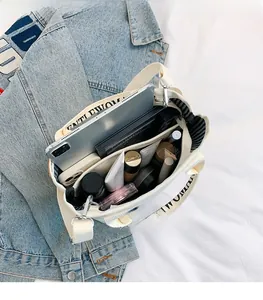Top view of canvas tote bag interior showing striped lining and multiple storage pockets