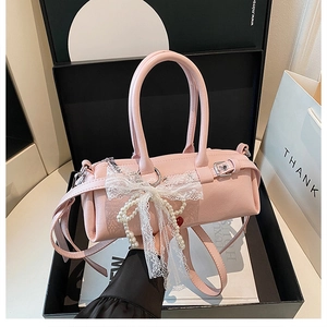 Dettaglio borsa Boston rosa chiaro con fiocco in pizzo, perle e finiture argentate