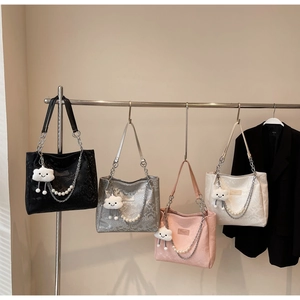 Detail of snake skin texture tote bags with pearl chain handles and plush cloud charms