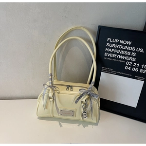 Detail of light yellow PU leather handbag with silk ribbon and plaid bow charm