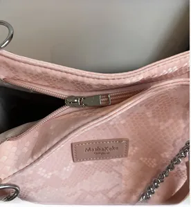 Close-up of pink snakeskin pattern tote bag with silver metal zipper and brand label