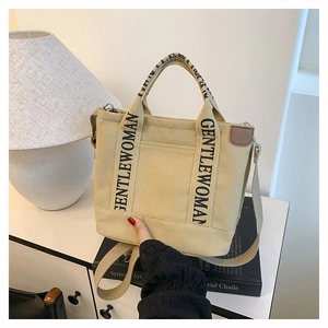 Detail of canvas tote bag with Gentlewoman logo handle and brown leather trim