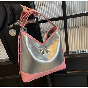 Close-up of metallic silver bow shoulder bag with pink leather trim and textured surface
