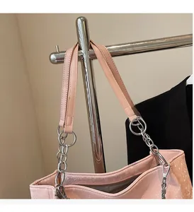 Detail of pink snake pattern tote bag featuring silver chain straps and zip closure