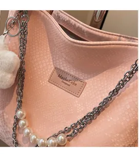 Close-up of pink snake skin texture tote bag with silver chain and pearl strap details