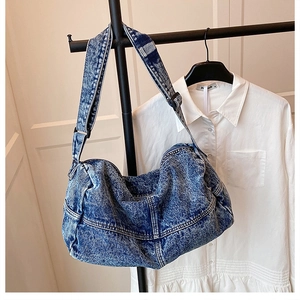 Close-up of acid wash denim tote bag showing distressed fabric texture and wide strap