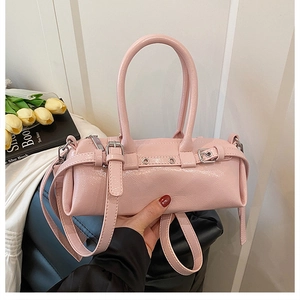 Dettaglio della borsa a cilindro rosa con finitura lucida e hardware in metallo argento