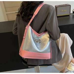 Close-up of pink and silver shoulder bag with bow detail and metallic pleated leather